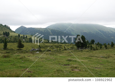 Wide angle landscape view on foggy mountains against a grey sky in the Carpathian alps, Austria Wide angle landscape view on foggy mountains against a grey sky in the Carpathian alps, Austria 108922902