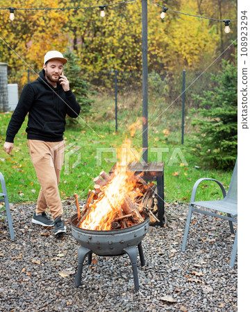 A man lights a barbecue in nature A man lights a barbecue in nature 108923294