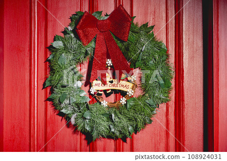 Front door at home painted red with a Christmas wreath, Xmas Garland Front door at home painted red with a Christmas wreath, Xmas Garland 108924031