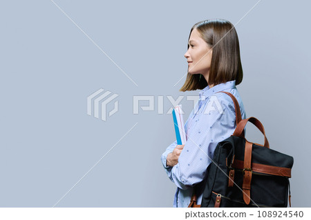 Profile view of young woman college student on gray background 108924540