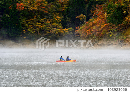 A canoe racing through Lake Kuzuryu in autumn leaves A canoe racing through Lake Kuzuryu in autumn leaves 108925066