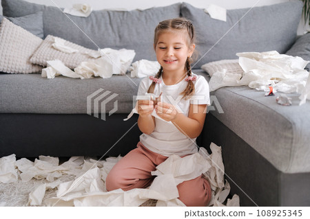 Little crafty girl eats sweets at home. Kid eating chocolate and have fun. Chaos at home 108925345