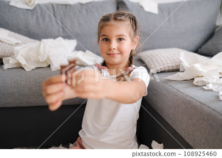 Little crafty girl eats sweets at home. Kid eating chocolate and have fun. Chaos at home 108925460