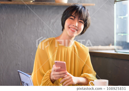 一位女士在咖啡館拿起智慧型手機，與「西點店情懷」合作拍攝 108925831