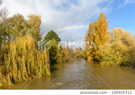 Rainbow over a flooded river. Autumn landscape. Rainbow over a flooded river. Autumn landscape. 108926312