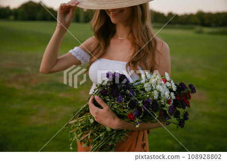 Beautiful hipster woman holding bunch of wildflower Beautiful hipster woman holding bunch of wildflower 108928802