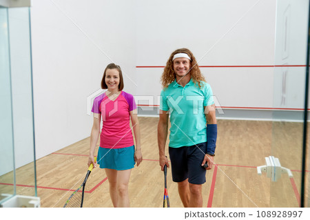 Satisfied man and woman athlete after successful squash game Satisfied man and woman athlete after successful squash game 108928997