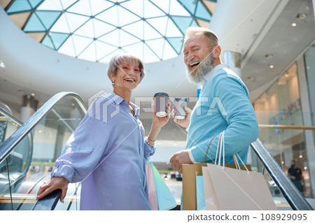 Adult senior couple with purchases having fun time at shopping mall 108929095