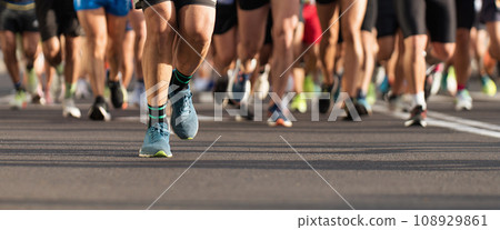 Marathon runners running on city road, large group of runners, close-up legs runners running sport marathon, male jogging race in asphalt road, athletics competition 108929861