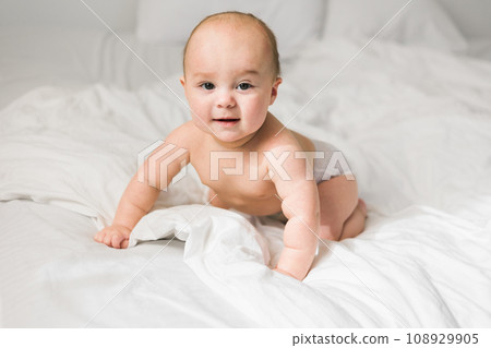 Happy baby lying on bed laughing. Generation alpha and gen alpha 108929905