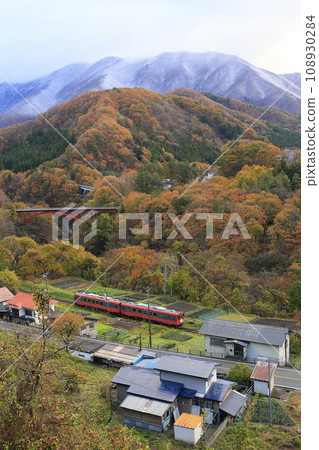 Aizu Railway with autumn leaves and snowy scenery 108930284