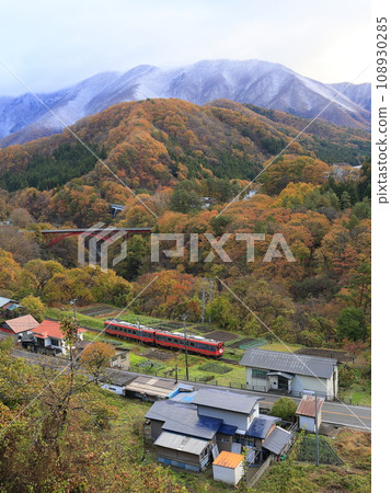 Aizu Railway with autumn leaves and snowy scenery 108930285