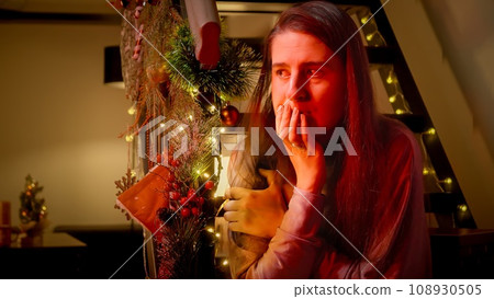 Police car lights illuminating the face of nervous and scared woman on Christmas night. Crime, problems with law and theft on winter holidays and celebrations. 108930505