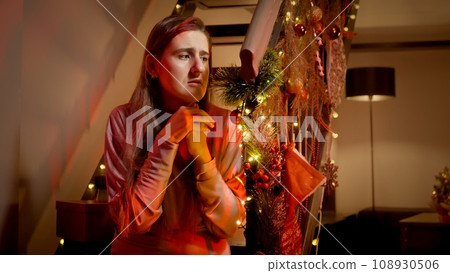 Scared woman calling 911 emergency for police or ambulance to come on Christmas night. Crime, ambulance, injury, problems with law and theft on winter holidays and celebrations. Scared woman calling 911 emergency for police or ambulance to come on Christmas night. Crime, ambulance, injury, problems with law and theft on winter holidays and celebrations. 108930506