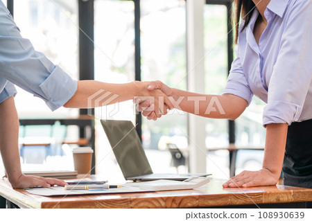 Two businesswomen shaking hands together after collaboration about marketing strategy of business Two businesswomen shaking hands together after collaboration about marketing strategy of business 108930639