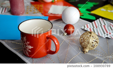 Closeup dolly shot of colorful paper, stickers, ribbons and glitter lying on desk. Making traditional Christmas decorations and ornaments Closeup dolly shot of colorful paper, stickers, ribbons and glitter lying on desk. Making traditional Christmas decorations and ornaments 108930789