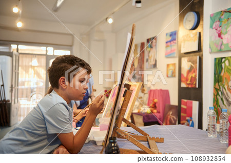 Authentic talented inspired teenager boy learning art and painting on canvas in the exhibition hall of art gallery 108932854