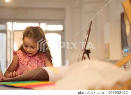 Caucasian adorable little child girl drawing picture in a creative art studio 108932912