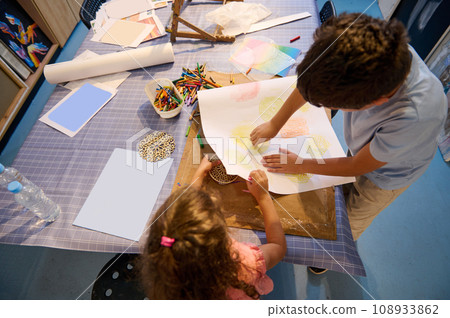 View from above of inspired children learning art, drawing with pencils in creative workshop. Elementary age school. View from above of inspired children learning art, drawing with pencils in creative workshop. Elementary age school. 108933862