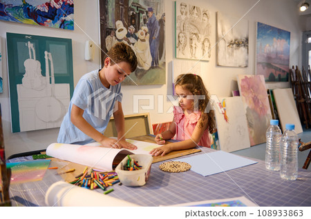 Two Caucasian adorable inspired children learning art, drawing with pencils in creative workshop. Elementary age school. 108933863