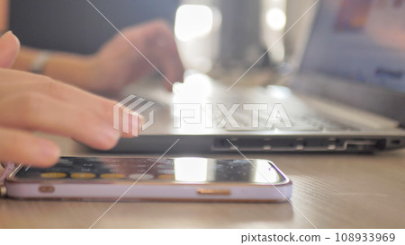 Close up of female accountant or banker making calculations on mobile phone. Home finances, investment, economy, saving money or insurance concept. Woman's hands closeup Close up of female accountant or banker making calculations on mobile phone. Home finances, investment, economy, saving money or insurance concept. Woman's hands closeup 108933969