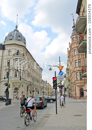 street with pedestrians and cyclist in Lodz. Young man athlete rides sports bike street with pedestrians and cyclist in Lodz. Young man athlete rides sports bike 108934379