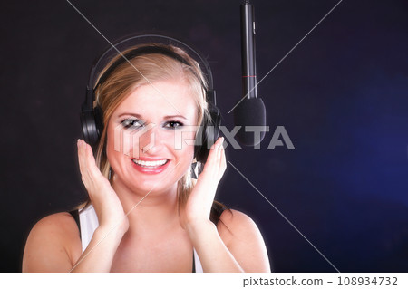 woman singing rock song microphone headphones 108934732