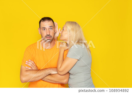 Relationships, love and couple concept: smiling girlfriend telling the secret to her boyfriend in his ear Relationships, love and couple concept: smiling girlfriend telling the secret to her boyfriend in his ear 108934892