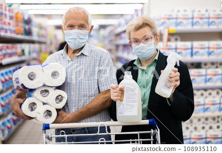 Elderly couple wearing a covid-proof mask selects paper in the supermarket department Elderly couple wearing a covid-proof mask selects paper in the supermarket department 108935110