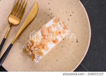 A piece of delicious sweet meringue roll with mascarpone cheese, berries and almonds A piece of delicious sweet meringue roll with mascarpone cheese, berries and almonds 108935137