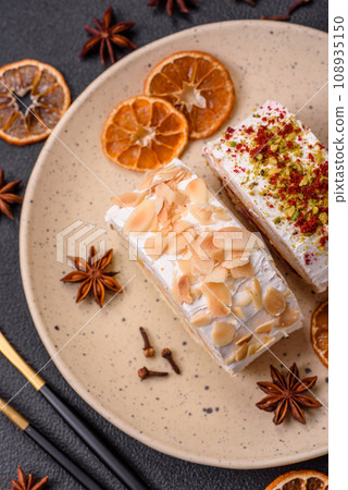 A piece of delicious sweet meringue roll with mascarpone cheese, berries and almonds 108935150
