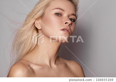Beautiful woman with magnificent blond hair. Happy model face with windswept flying hair. Shiny long health hairstyle 108935169