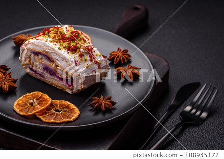 A piece of delicious sweet meringue roll with mascarpone cheese, berries and almonds A piece of delicious sweet meringue roll with mascarpone cheese, berries and almonds 108935172