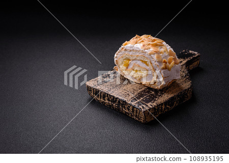 A piece of delicious sweet meringue roll with mascarpone cheese, berries and almonds A piece of delicious sweet meringue roll with mascarpone cheese, berries and almonds 108935195