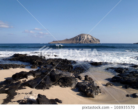 Wave crashing at Baby Makapuu with Rabbit Island in the Distance 108935570