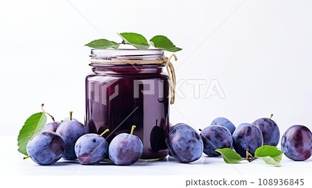 Plums and plum jam in a glass jar on a white table. Plum jam on a white background. 108936845
