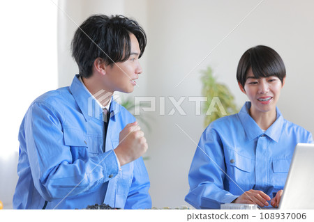 Two male and female engineers having a discussion about prototypes such as circuit boards while looking at a PC 108937006