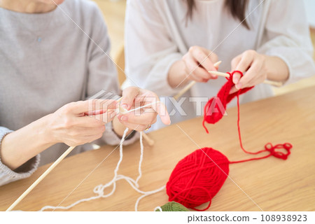 Hands of a senior woman and a young woman knitting Hands of a senior woman and a young woman knitting 108938923