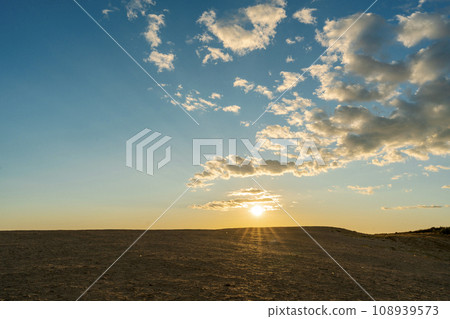 At dusk, sand dunes, blue sky, sun At dusk, sand dunes, blue sky, sun 108939573