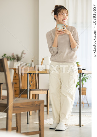 A woman who drinks coffee in a room 108939657