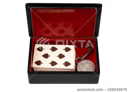 vintage old black and red casket with vintage playing cards and silver dollar coins 108939678