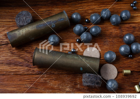 Antique 16-gauge brass ammo cases and led bullets for cartridge reloading. Antique 16-gauge brass ammo cases and led bullets for cartridge reloading. 108939692