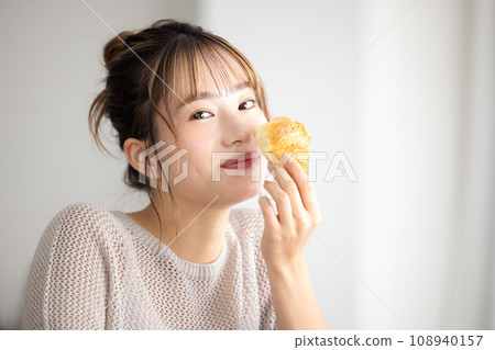 A woman eating bread A woman eating bread 108940157