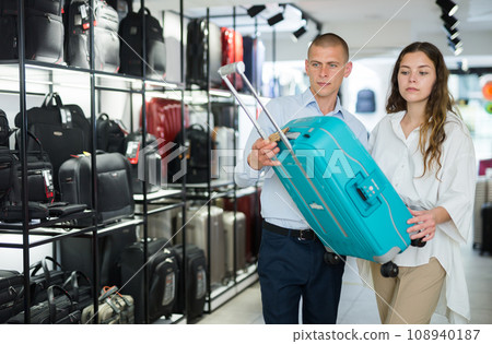 Man and woman buying suitcase in store Man and woman buying suitcase in store 108940187