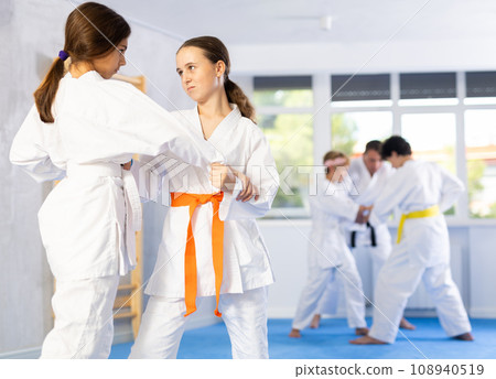 Children athletes in pair conduct training battle in oriental fighting technique 108940519
