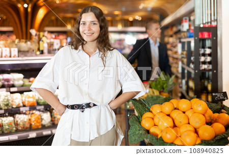 Portrait of a smiling girl standing in the supermarket department 108940825