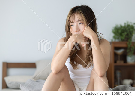 Beauty: A woman relaxing while sitting on the bed Beauty: A woman relaxing while sitting on the bed 108941004