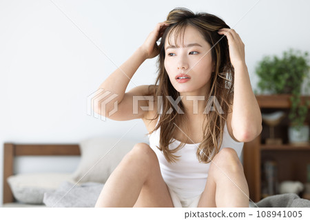 Beauty: A woman relaxing while sitting on the bed 108941005