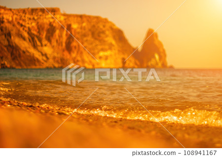 Abstract nature summer ocean sunset sea background. Small waves on water surface in motion blur with bokeh lights from sunrise. Holiday, vacation and recreational background concept Abstract nature summer ocean sunset sea background. Small waves on water surface in motion blur with bokeh lights from sunrise. Holiday, vacation and recreational background concept 108941167