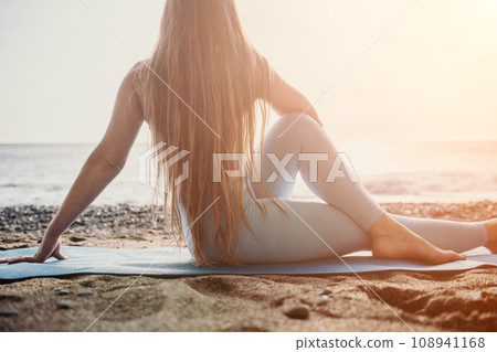 Woman sea pilates. Sporty happy middle aged woman practicing fitness on beach near sea, smiling active female training on yoga mat outside, enjoying healthy lifestyle, harmony and meditation. Woman sea pilates. Sporty happy middle aged woman practicing fitness on beach near sea, smiling active female training on yoga mat outside, enjoying healthy lifestyle, harmony and meditation. 108941168
